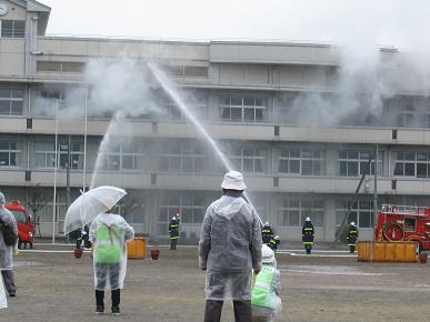 地元消防団員による放水訓練の写真"